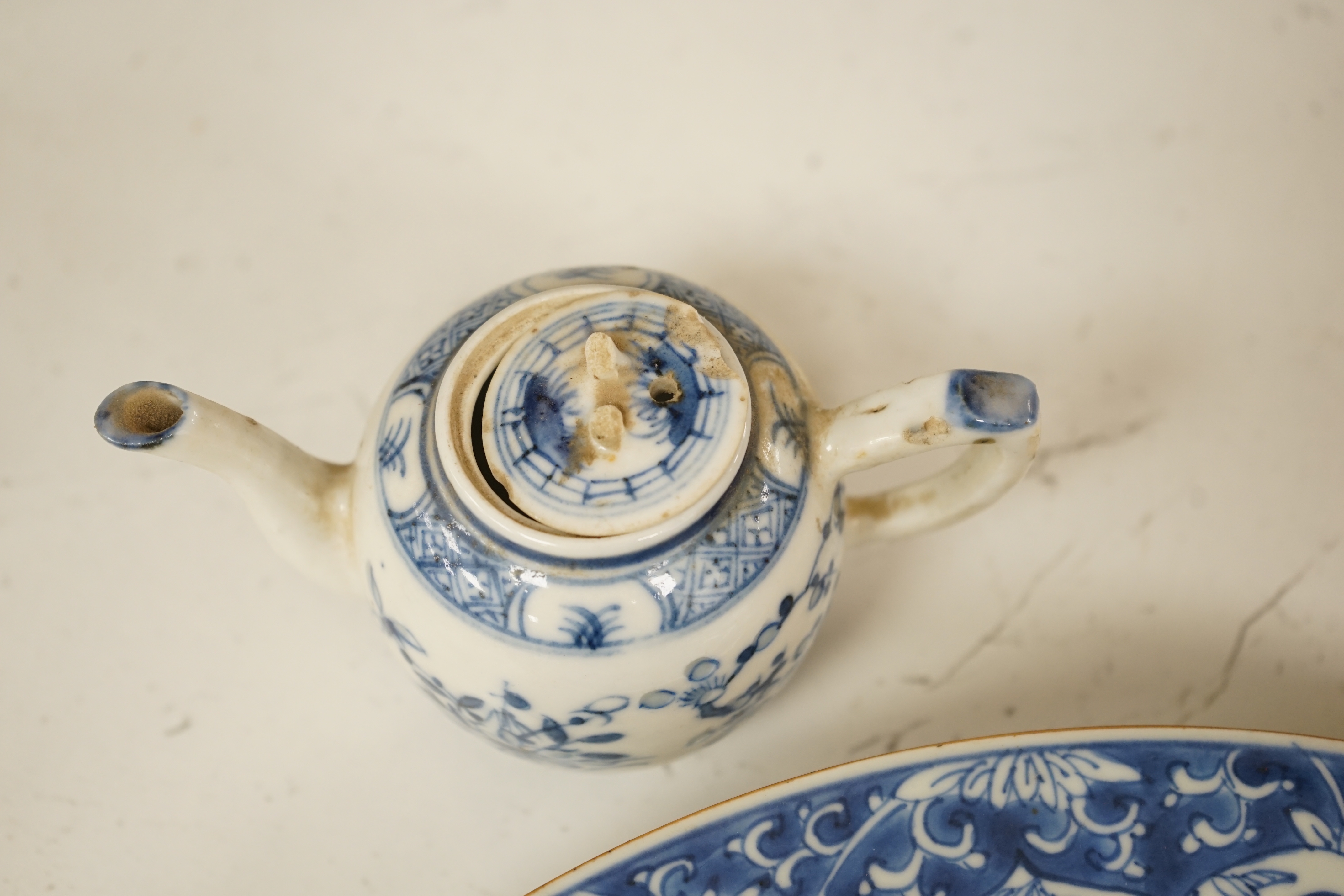 A Worcester teapot, c.1770, two 18th century Chinese porcelain dishes, a cup and saucer, a Chinese shallow bowl and a small teapot, largest dish 39cm